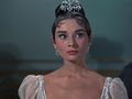 Na zdjęciu młoda kobieta w eleganckiej sukni wieczorowej, z diademem na głowie i delikatnym makijażem.