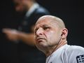 Jacek Murański w białej koszulce, słuchający muzyki, z wyrazem skupienia na twarzy.