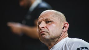 Jacek Murański w białej koszulce, słuchający muzyki, z wyrazem skupienia na twarzy.
