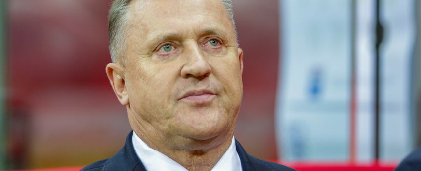 Cezary Kulesza w garniturze z niebieskim krawatem, w skupieniu patrzy w stronę obiektywu.