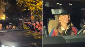 Anna Lewandowska za kółkiem, uśmiecha się, wokół tłum ludzi robiących zdjęcia. Nocna sceneria.