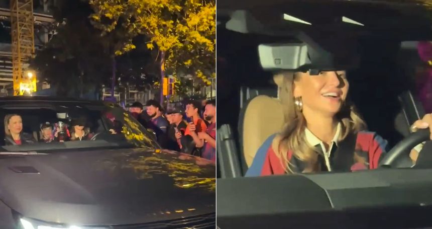 Anna Lewandowska za kółkiem, uśmiecha się, wokół tłum ludzi robiących zdjęcia. Nocna sceneria.