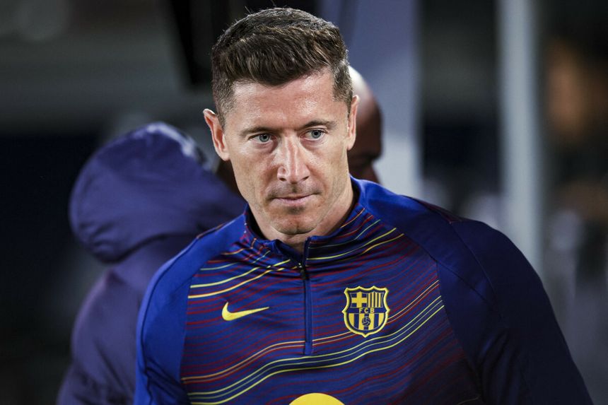 Robert Lewandowski w bluzie FC Barcelony, z poważnym wyrazem twarzy.