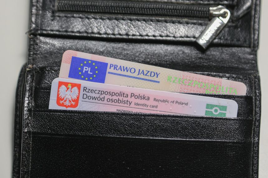 Portfel z dokumentami: dowód osobisty i prawo jazdy w czarnej skórzanej kieszeni.