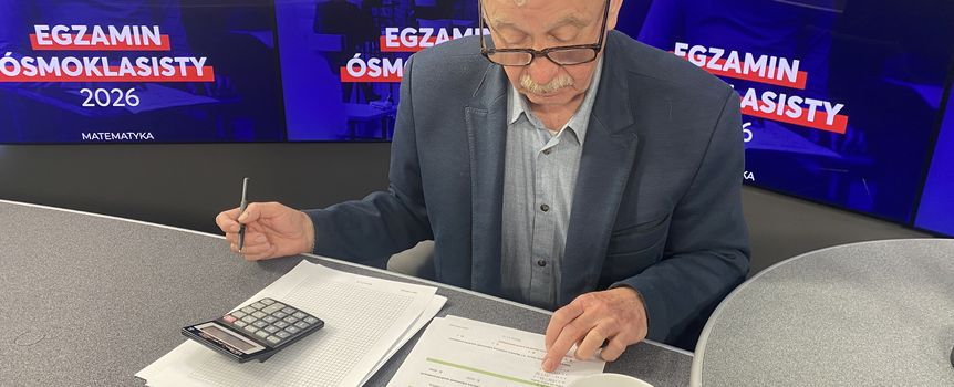 Mężczyzna w okularach przegląda dokumenty i kalkulator w studio radiowym. W tle hasła o egzaminie.