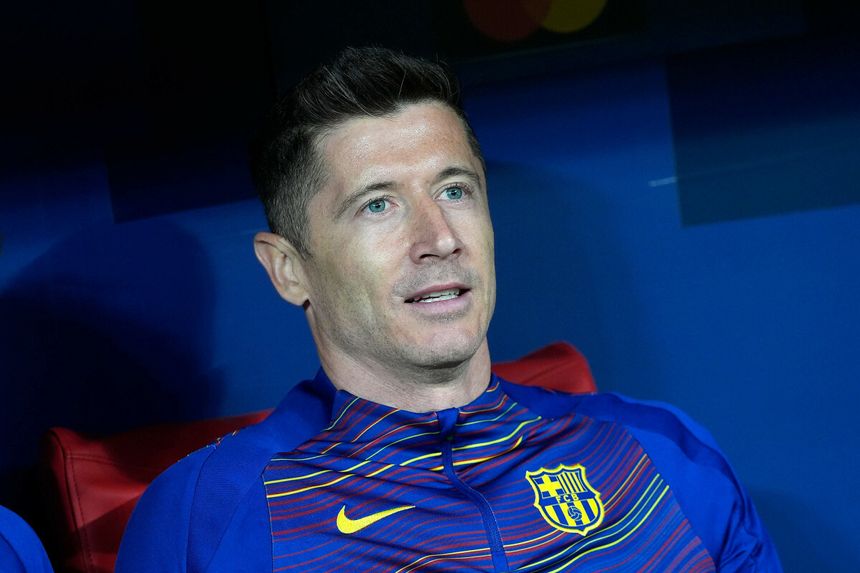 Na zdjęciu Robert Lewandowski w niebieskiej bluzie FC Barcelona, siedzący na ławce rezerwowych.