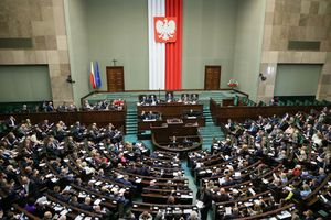 Zgromadzenie w Sejmie, z flagą Polski i orłem na ścianie, wielu przedstawicieli w sali.