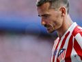 Antoine Griezmann w czerwono-białym stroju Atletico Madryt, z zamyśloną miną, na stadionie.