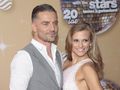 Agnieszka Kaczorowska i Marcin Rogacewicz uśmiechają się na czerwonym dywanie. Tło z dyskotekową kulą.