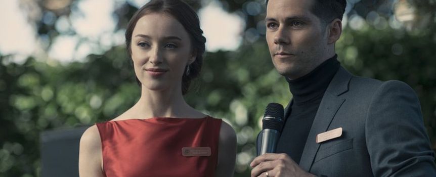 Para młodych ludzi na scenie, mężczyzna trzyma mikrofon, kobieta w czerwonej sukience.