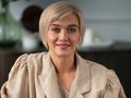 Kobieta z krótkimi blond włosami w jasnej bluzie, uśmiechająca się do aparatu.