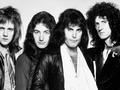 Muzycy z legendarnego zespołu Queen z długimi włosami w skórzanych kurtkach, w czarno-białym zdjęciu.