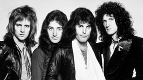 Muzycy z legendarnego zespołu Queen z długimi włosami w skórzanych kurtkach, w czarno-białym zdjęciu.