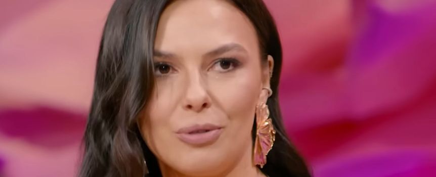 Na zdjęciu młoda kobieta z długimi ciemnymi włosami, w eleganckich kolczykach, patrzy w kamerę.