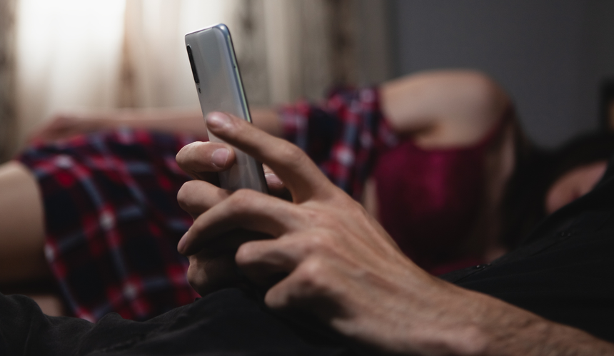 Mężczyzna korzystający z telefonu przy partnerce