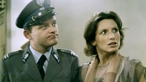 Para osób – mężczyzna w mundurze milicyjnym i kobieta w bluzce patrzą na siebie zaskoczeni.