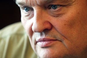 Zbliżenie na twarz mężczyzny z niebieskimi oczami i poważnym wyrazem twarzy.
