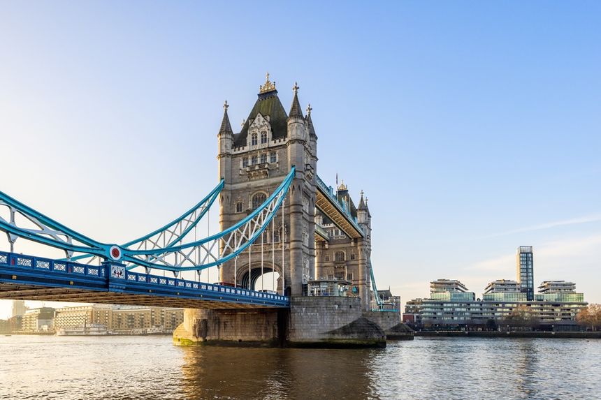 Widok na Tower Bridge w Londynie, z rzeką i nowoczesnymi budynkami w tle.