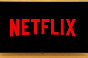 Ekran telewizora z logo Netflix w dużych czerwonych literach na czarnym tle.