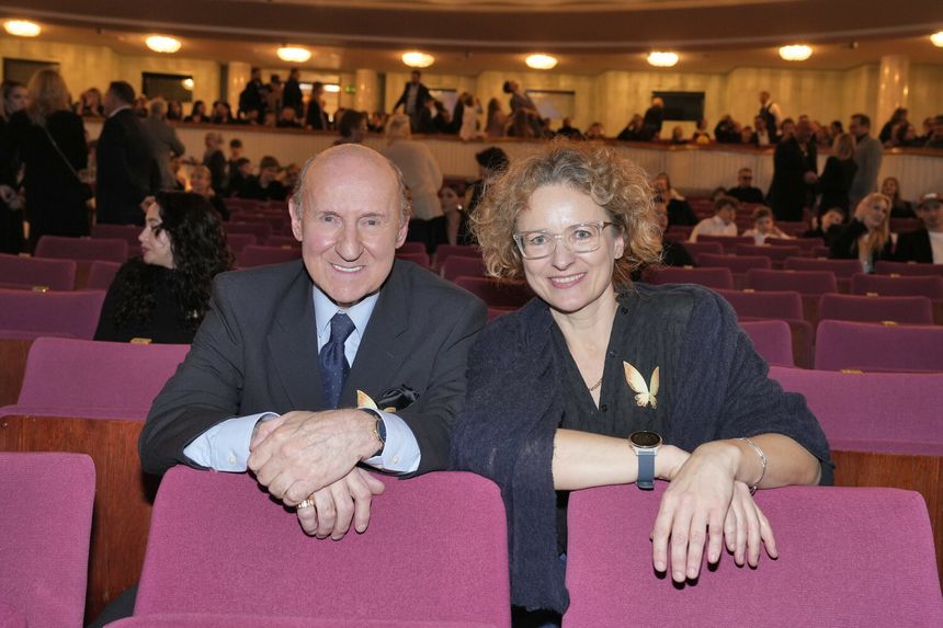 Mężczyzna i kobieta siedzą na różowych fotelach, uśmiechają się. W tle widać gości wydarzenia.