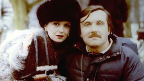Para ludzi uśmiechających się do kamery, w zimowej scenerii, kobieta w futrze, mężczyzna z wąsami.