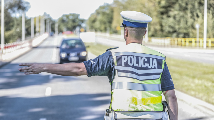 Policjant ztrzymuje samochód - materiał poglądowy