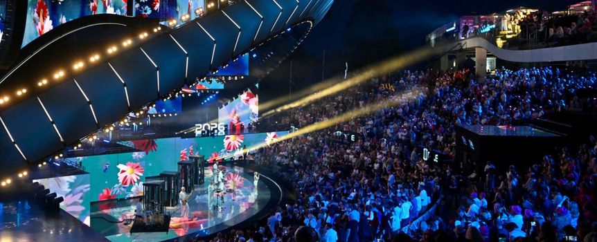 Na scenie koncertowej tłum ludzi, kolorowe światła i dynamiczna atmosfera wieczoru.