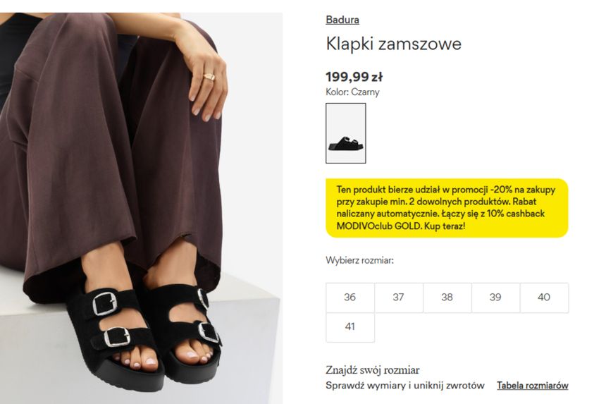 Czarne klapki zamszowe z dwiema klamrami na białym tle, w eleganckim stylu.