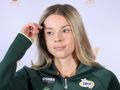 Maja Chwalińska w zielonym dresie, z długimi, prostymi włosami, dotyka dłonią czoła.