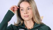 Maja Chwalińska w zielonym dresie, z długimi, prostymi włosami, dotyka dłonią czoła.