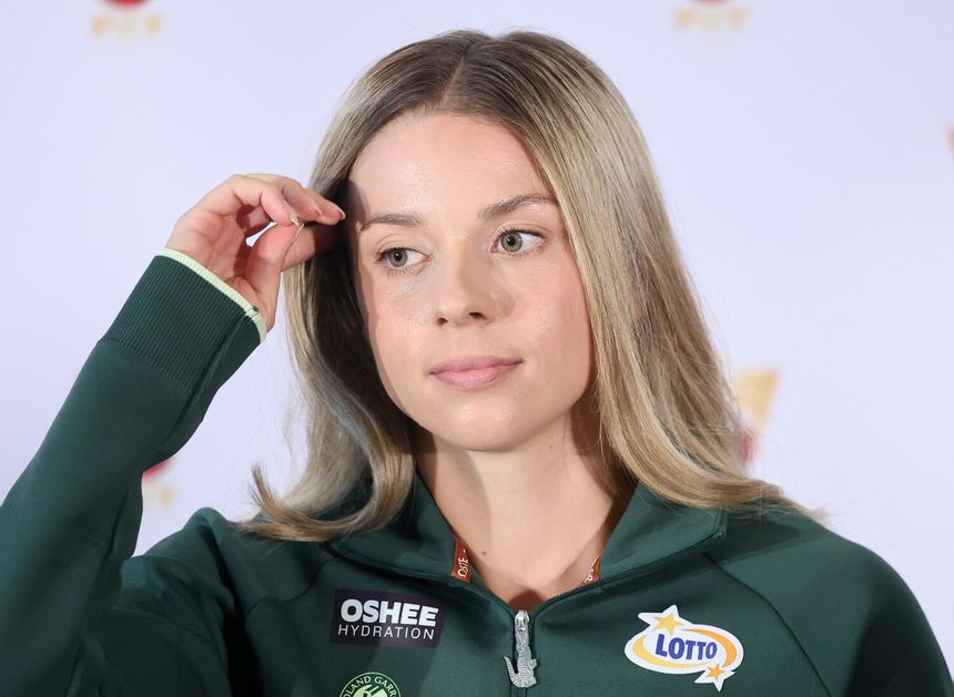 Maja Chwalińska w zielonym dresie, z długimi, prostymi włosami, dotyka dłonią czoła.