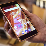 Na zdjęciu widoczny jest telefon komórkowy trzymany w dłoni. Ekran wyświetla aplikacje.