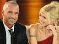 Na zdjęciu uśmiechnięta para w eleganckim stylu, siedzą na kanapie w studiu telewizyjnym.