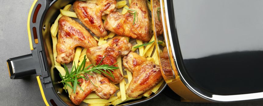 Smażone skrzydełka z kurczaka na frytkach, podane w elektrycznym frytkowniku.