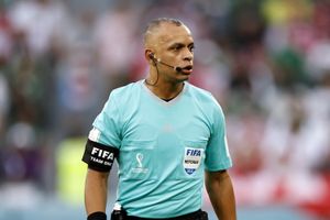 Wilton Sampaio w niebieskim stroju, z opaską FIFA, podczas meczu na stadionie.