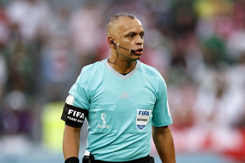 Wilton Sampaio w niebieskim stroju, z opaską FIFA, podczas meczu na stadionie.