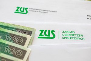 Na zdjęciu widoczne koperty z logo ZUS oraz banknoty 100-złotowe.
