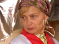 Nie rozpoznaję osoby na zdjęciu. Opis: Kobieta z blond włosami w chustce, z wyrazem twarzy w zamyśleniu.