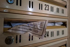 Widok skrzynek pocztowych z kartką wystającą z jednej z nich.