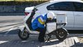  Kurier odpoczywa na swoim rowerze elektrycznym. Pekin, marzec 2024 r.