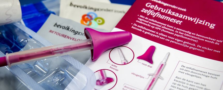 Zestaw do samodzielnego badania, różowa strzykawka i instrukcja obsługi na stole.