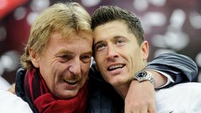 Zbigniew Boniek i Robert Lewandowski przytulają się, celebrując radośnie. W tle rozmyte kolory i konfetti.