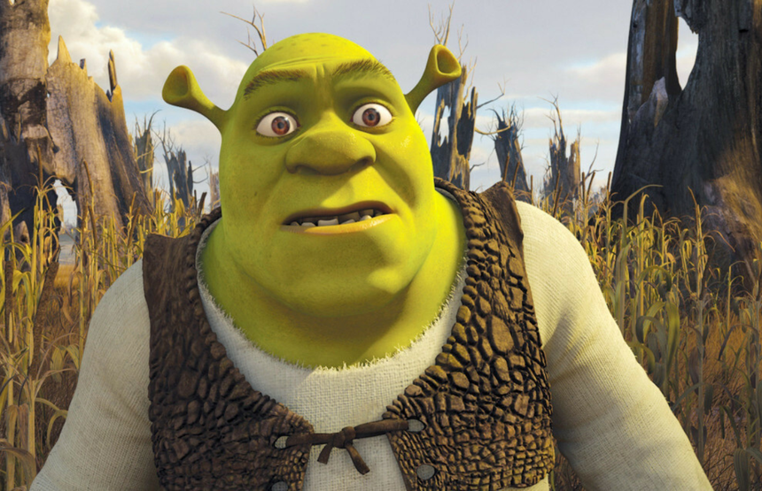 Shrek, zielony ogr z wyrazem zdziwienia, stoi wśród uschniętych drzew i traw.