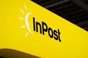Logo firmy InPost na żółtym tle. Symbol słońca obok napisu.