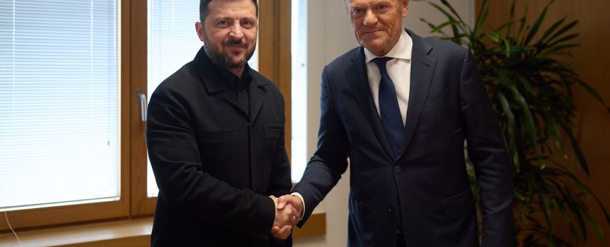 Na zdjęciu dwóch mężczyzn uściskiem dłoni przy oknie. W tle rośliny.