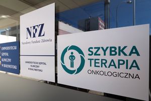Logo NFZ oraz szybkiej terapii onkologicznej na tle budynku szpitala w Białymstoku.