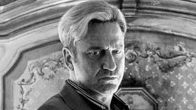 Mężczyzna z krótkimi, blond włosami, w trudnej, zamyślonej minie.