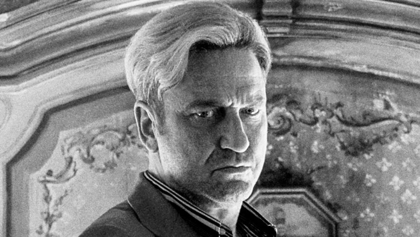 Mężczyzna z krótkimi, blond włosami, w trudnej, zamyślonej minie.