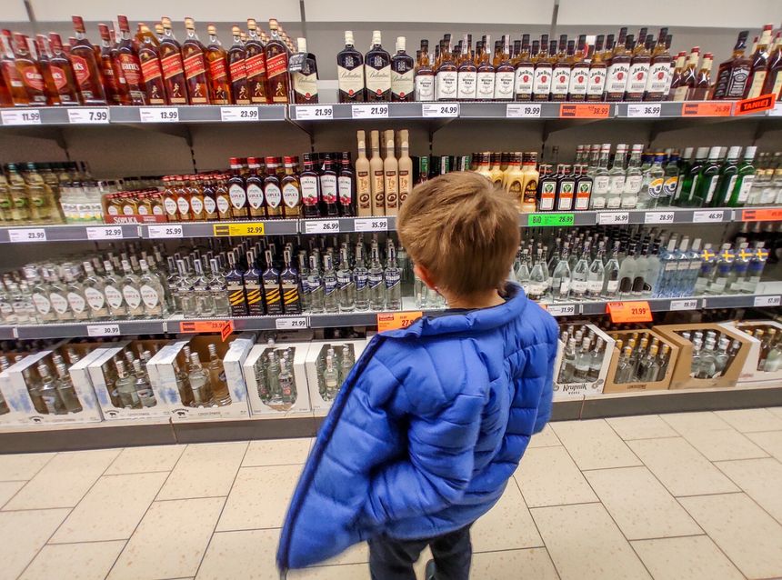 chłopiec patrzy na alkohole