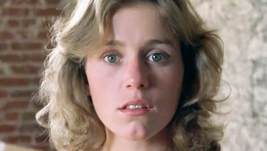Młoda kobieta z falującymi włosami i niebieskimi oczami, patrząca w kamerę.